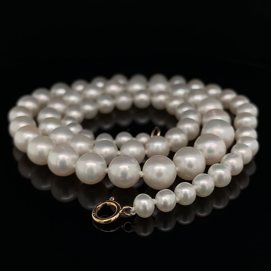 A
							pearl necklace on a table in a spiral